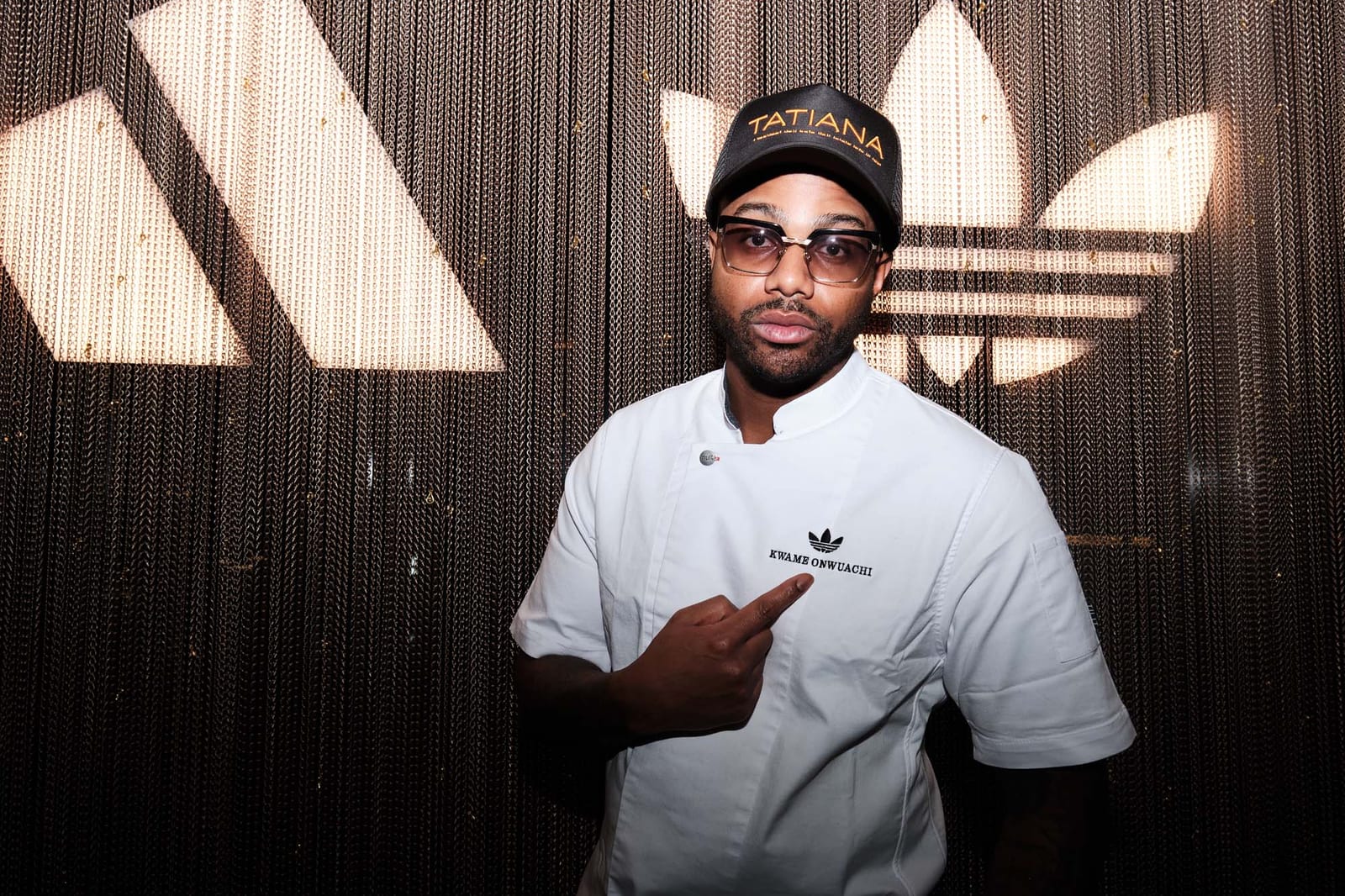A chef in whites in front of the trefoil wall