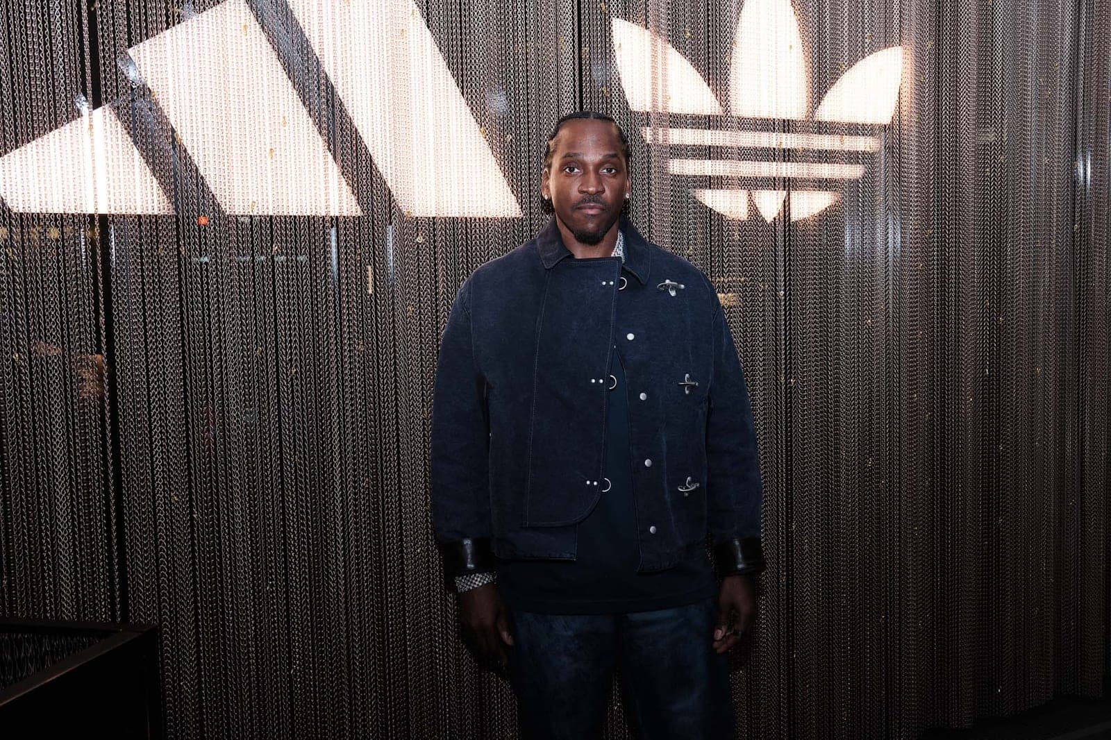 A guest in a navy jacket under the trefoil light
