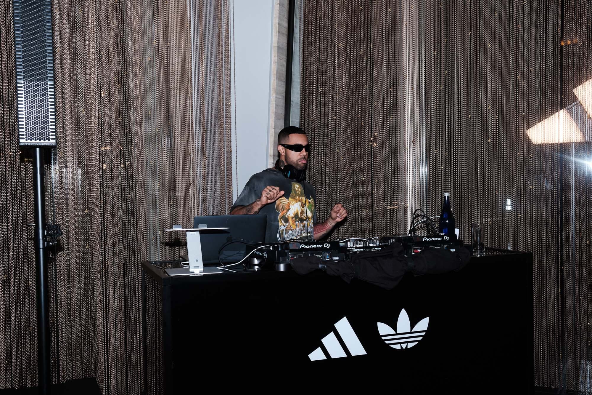 A DJ playing behind a branded booth