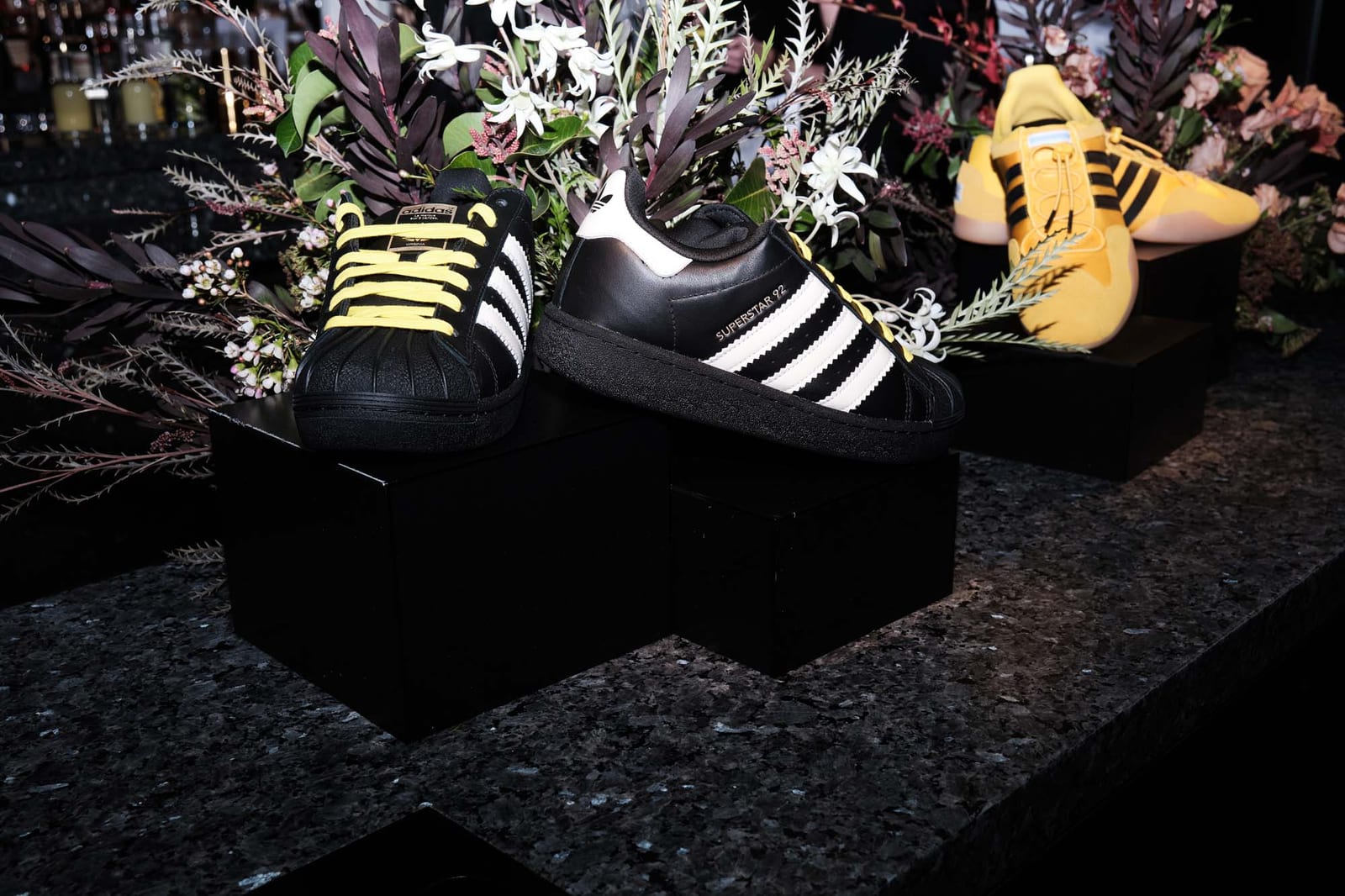 Trainers displayed among dark cut flowers