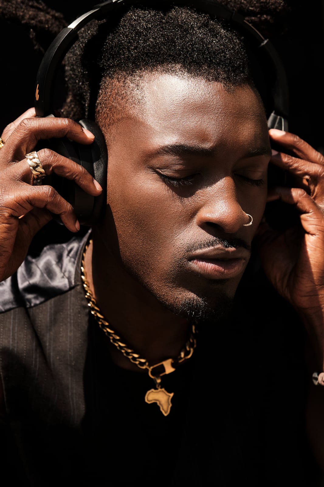 A man adjusting his headphones in low light