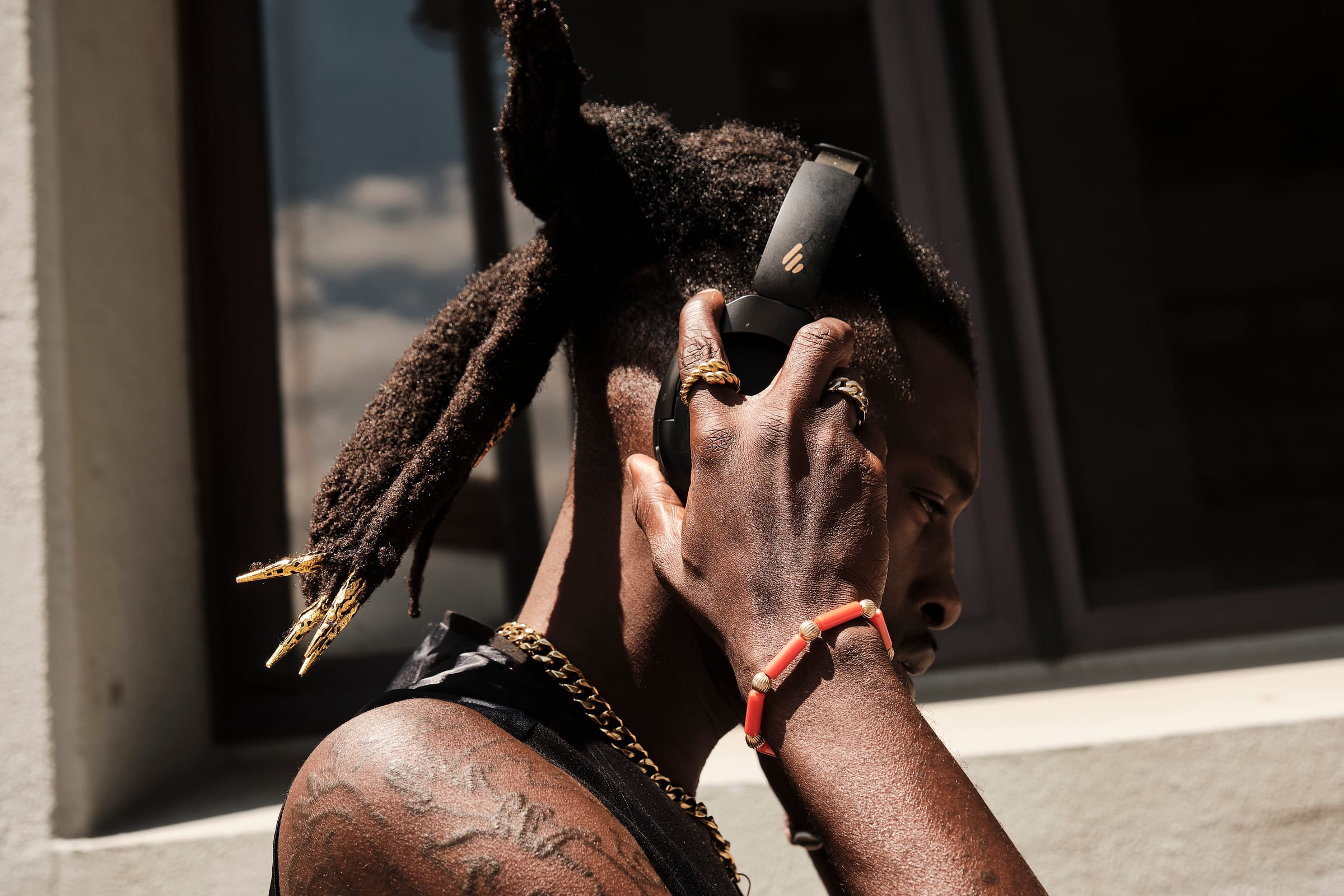 Hands with gold rings lifting headphones into place