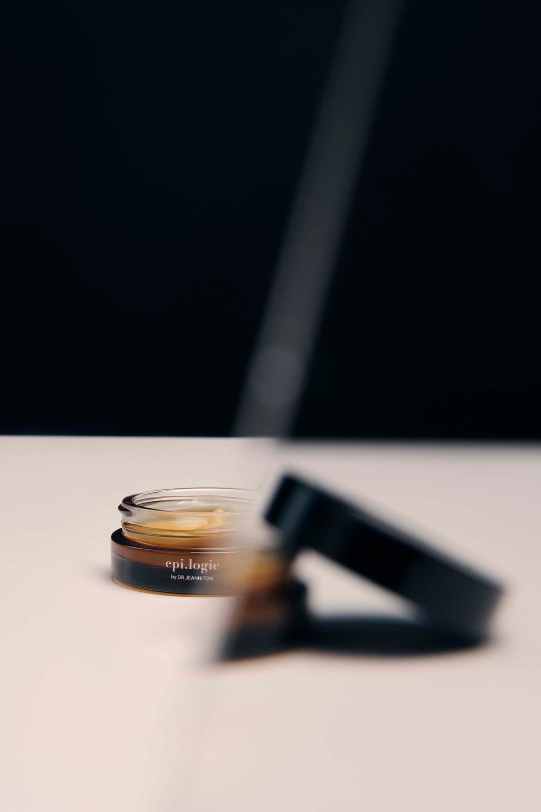 An open jar with the lid laid beside it