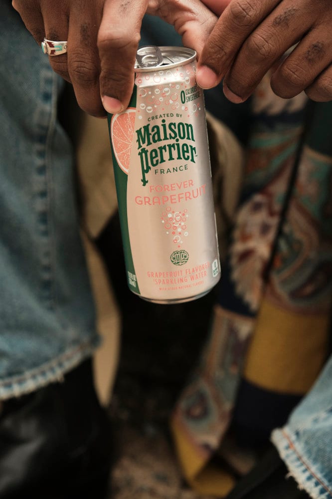 A can held low against a camel coat