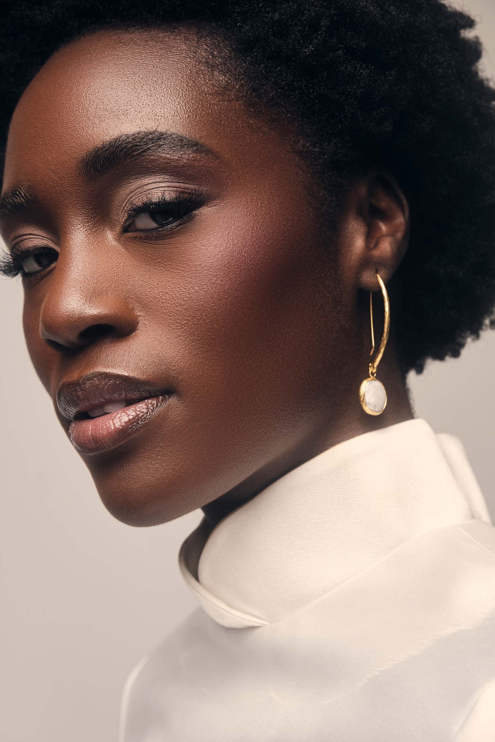 A portrait in a white collar with a pearl drop earring